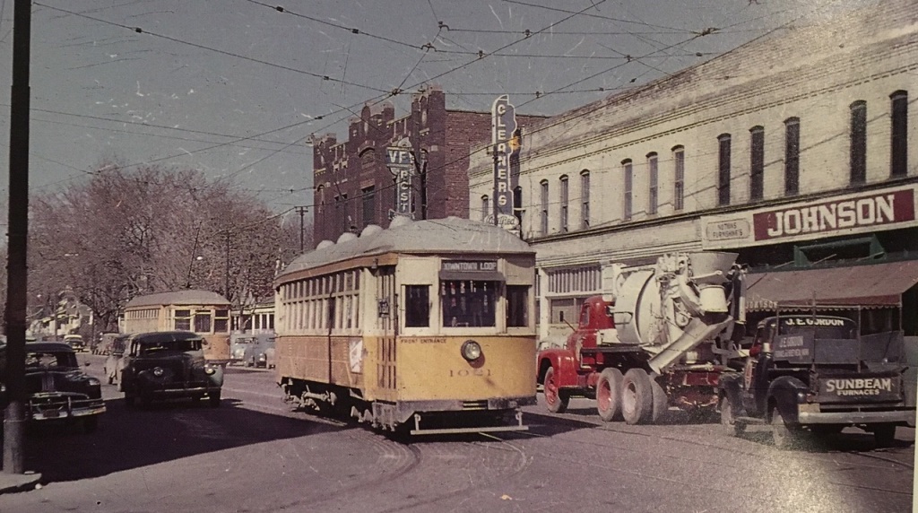 This is a picture of the building at North 24th and Ames. Richard Orr took it in the 1950s to highlight the streetcar. Behind that, you can see the Druid Hall, which is now on the National Register of Historic Places; a cleaners; the Star Liquor Store; and LaRue's Barbershop. Johnson's was a Rexall Drug Store.