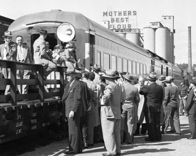 In 1954, this crowd of Omaha businessmen hopped onto a Missouri Pacific Railroad train at the Webster Street Station to tour the Belt Line Railway as a promotion for the space available to build along the tracks around town. Notice the Storz Brewery smokestack and Mother's Best Flour ad in the background.
